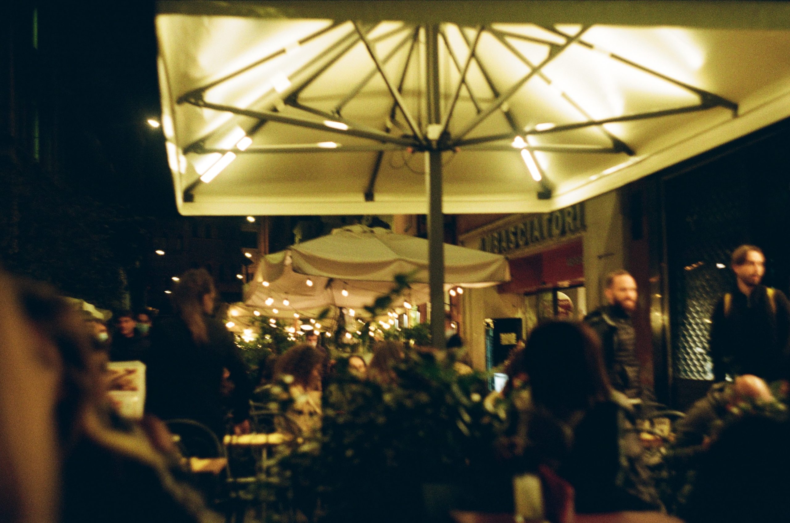 People eating and drinking in an outdoor area of a bar and restaurant