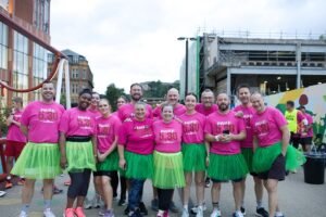 poppleston allen team dressed in bright pink t-shirts, green tutus and running kit before the race